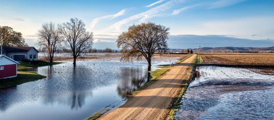 Terrain en zone inondable mis en vente avec panneau immobilier, risque d'inondation visible