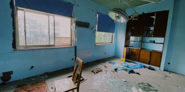 Une photo d'un petit studio dégradé, avec des murs abîmés, une fenêtre vétuste